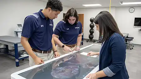 Students working with digital health care equipment.