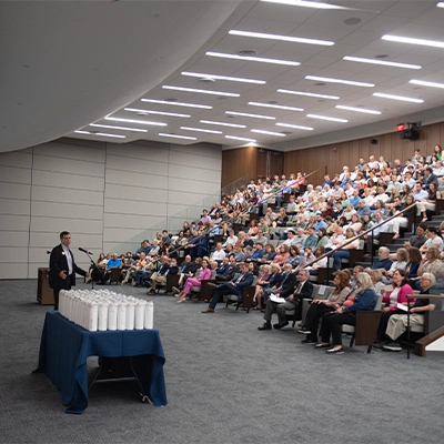 Dr. Haymond speaking to audience in Scharnberg Business and Communication Center auditorium.