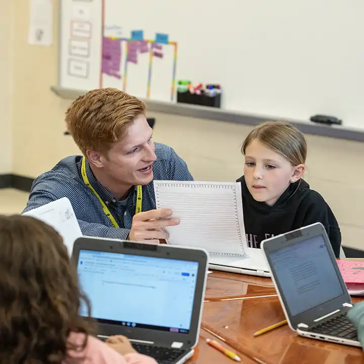 Male teacher educating a small group of children.