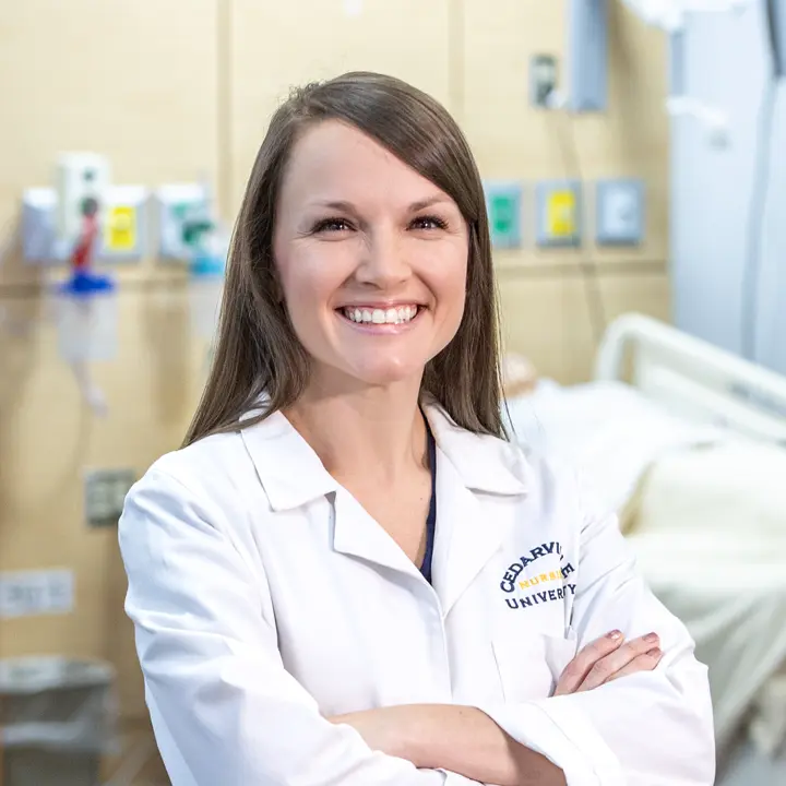 Female nursing faculty wearing a white lab coat.