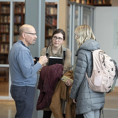 Adults in warm clothes outside talking.