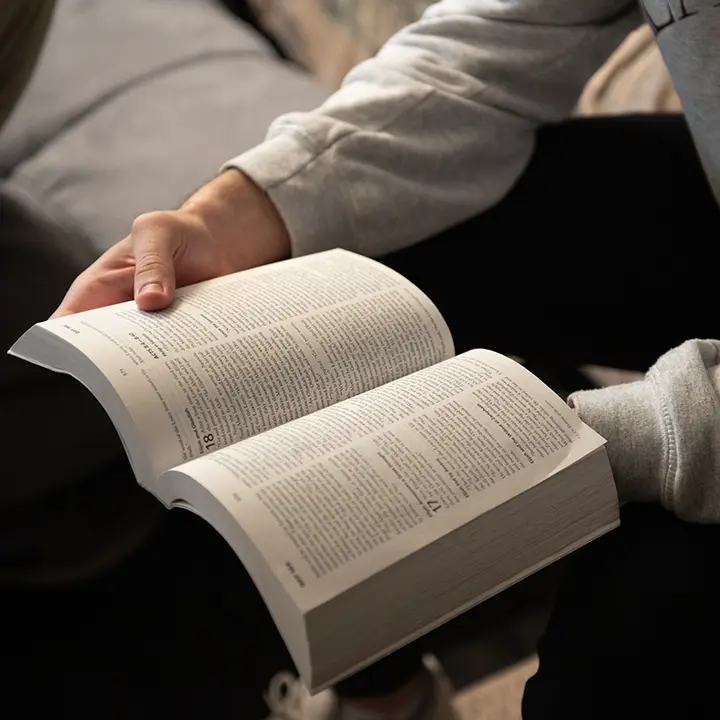 Man holding an open Bible.