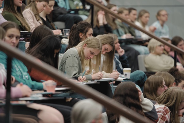 Female attendees taking notes during the event
