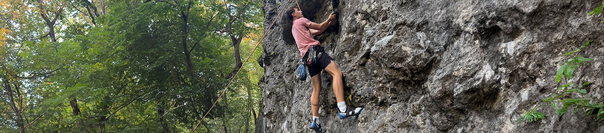 Seth Enloe climbing a rock wall.