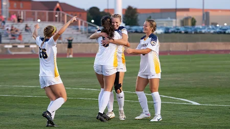 Women's soccer players celebrating.