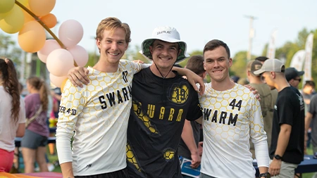Three college students wearing ultimate frisbee jerseys