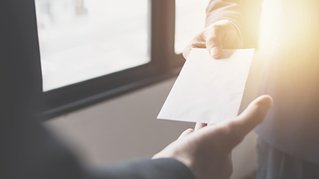 Two people exchanging an envelope