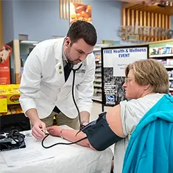 A Cedarville University pharmacy student checks a woman's blood pressure