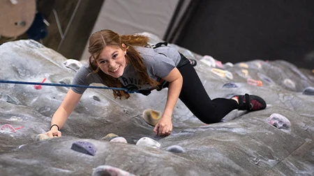Student climbing climbing wall