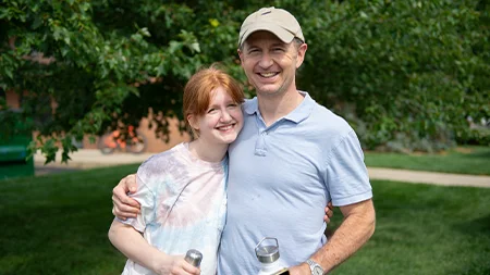 Student smiling with dad outside.