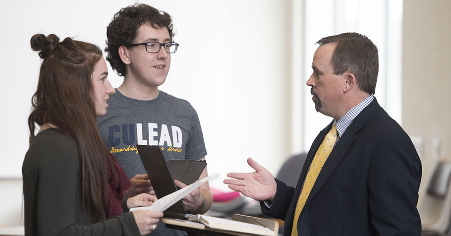 Dr. Jason Lee talking with female and male student