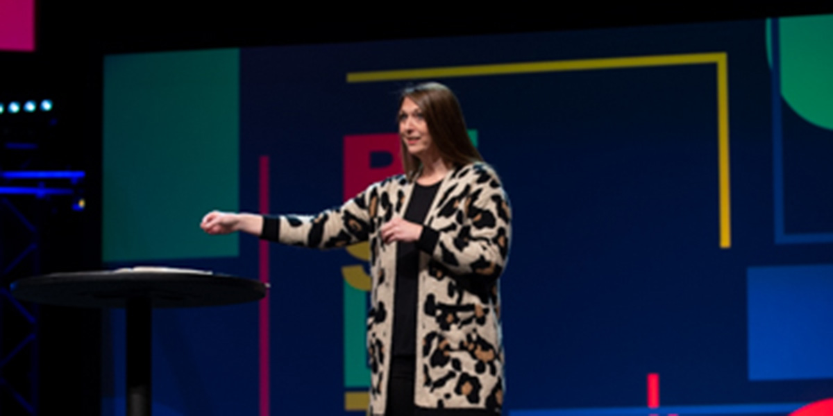 Mindy May speaking on stage.