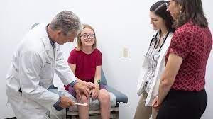 PA  professor examines a girl while students look on.