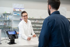 Pharmacist assisting a customer with a question about and over-the-counter product
