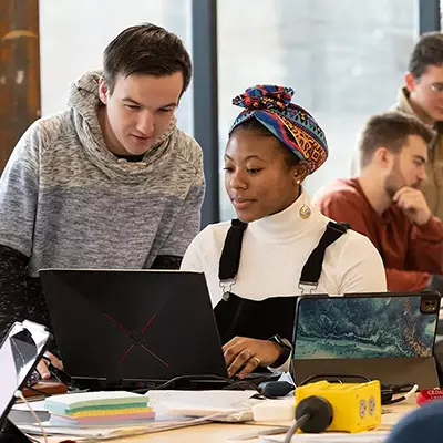 Students viewing a laptop together.