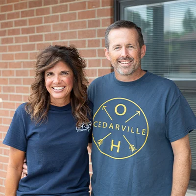Parents smiling outside of residence hall.