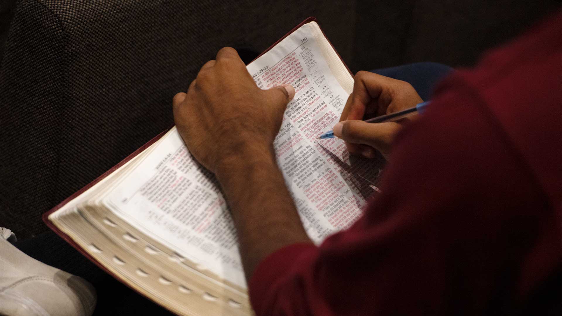 Student highlighting Bible verse.