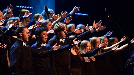 Worship choir singing and lifting their hands