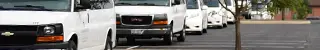 Fleet of university vans parked bumper to bumper