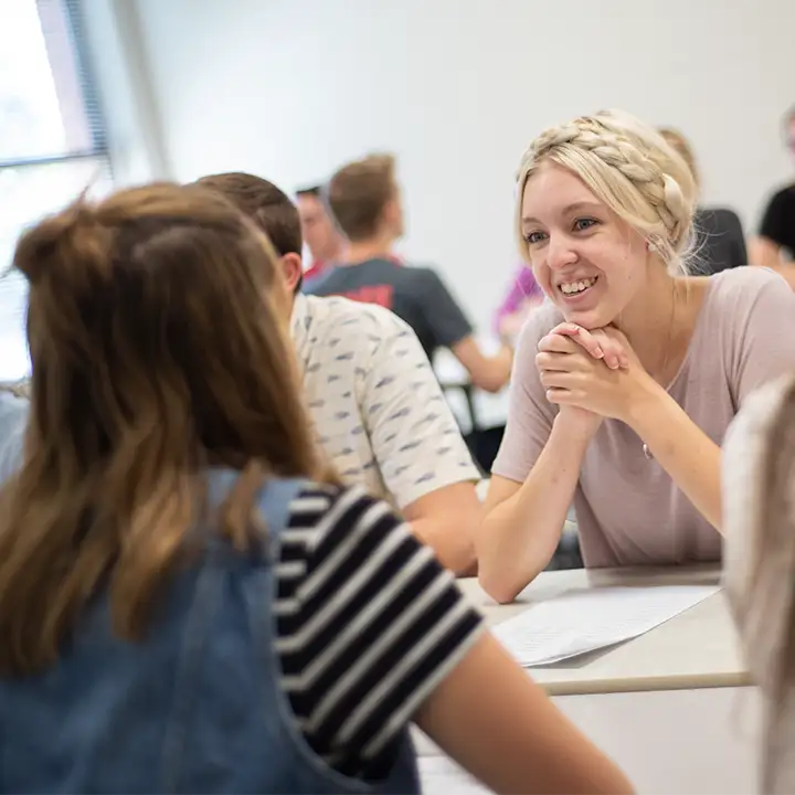 Woman smiling in room full of people