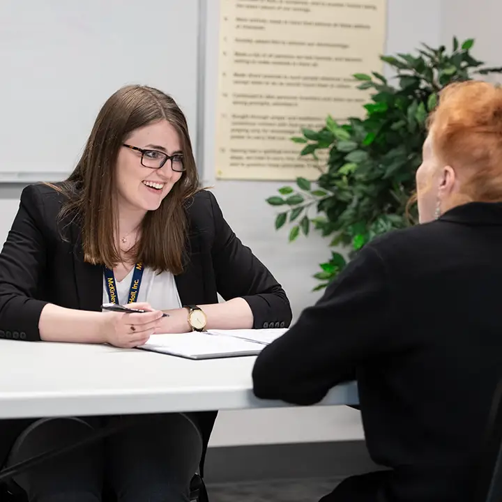 Two people seated at a table and talking.
