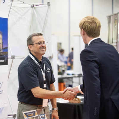 Student shaking employer's hand at career fair