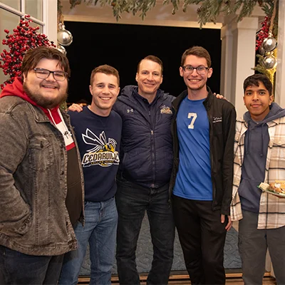 Dr. White smiling with students at his house.